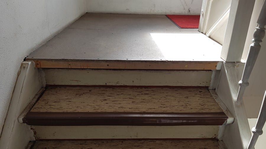 Treppenhaus mit ökologischem Linoleumbelag — das Podest mit freigelegtem Untergrund, alter Belag entfernt