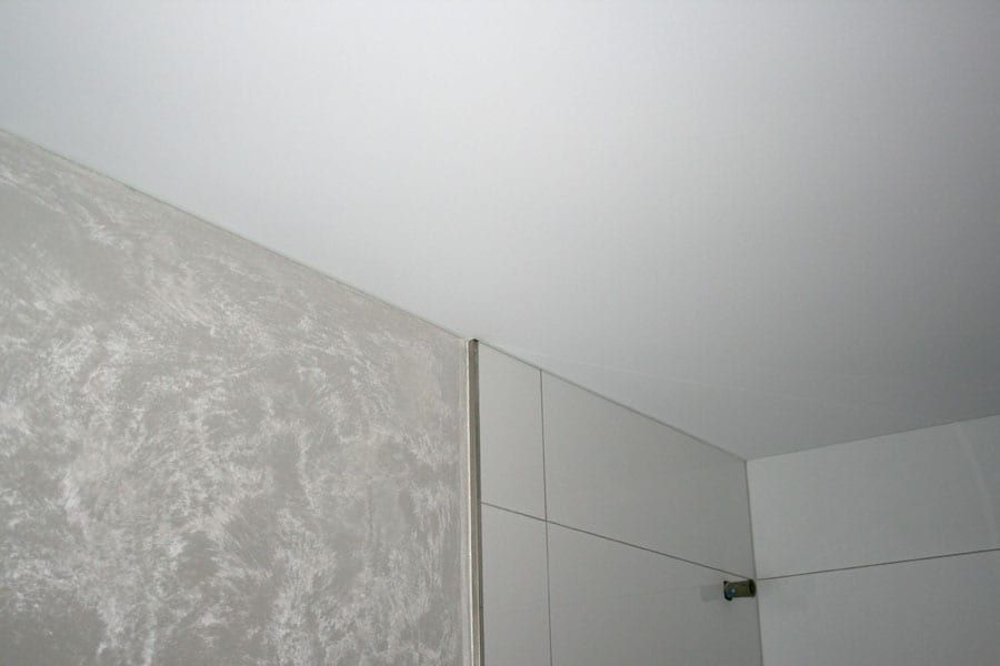 Badezimmer mit Spanndecke und Lasurwänden — die Lasur läuft bis an die Glaskante der Dusche