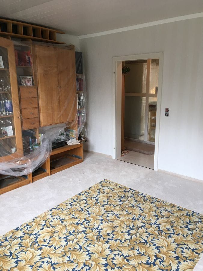 Teppichboden mit umlaufendem Fries — Blick zur Zimmertür, der Fries läuft an der Wand entlang