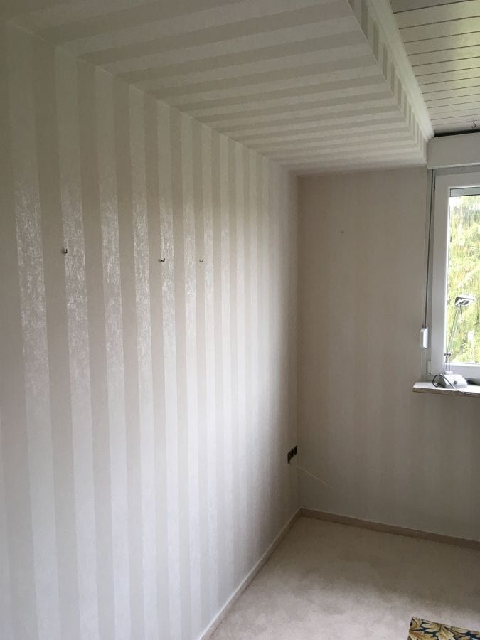 Teppichboden mit umlaufendem Fries — der tapezierte Raum, Blick auf die Wand mit dem Streifenmuster