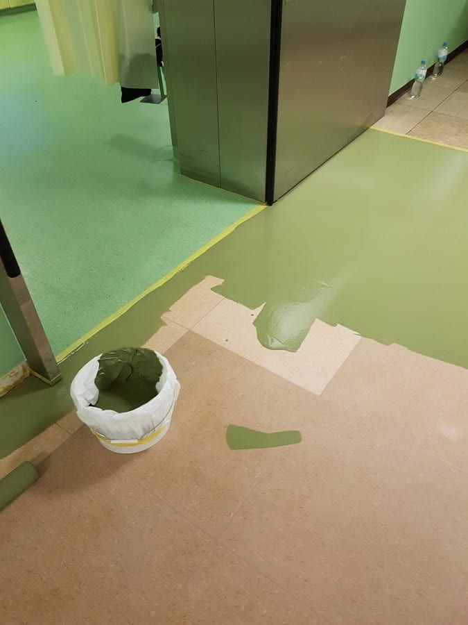 Untergrund für Industrieböden vorbereitet — erste grüne Bahn am Schrank, Untergrund davor freigelegt