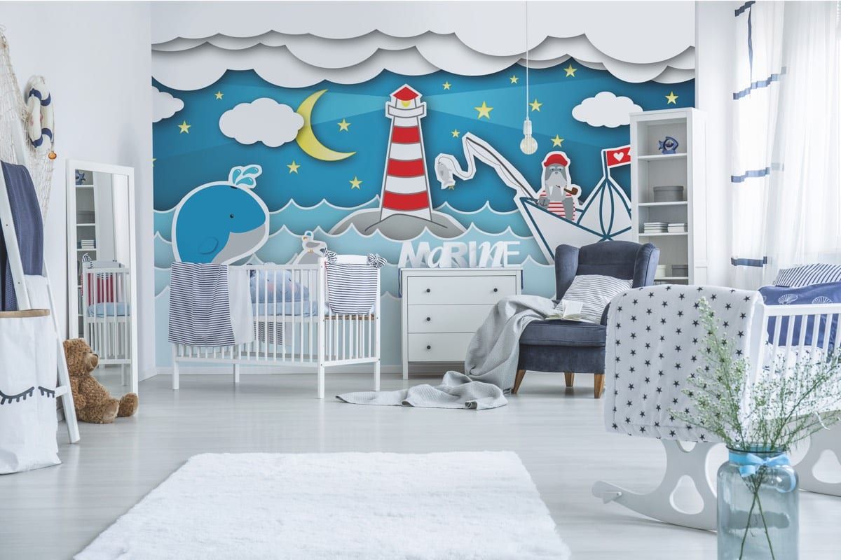 Kindertapete mit freundlichen Motiven — Leuchtturm, Wal und Papierboot in Blau hinter dem Kinderbett