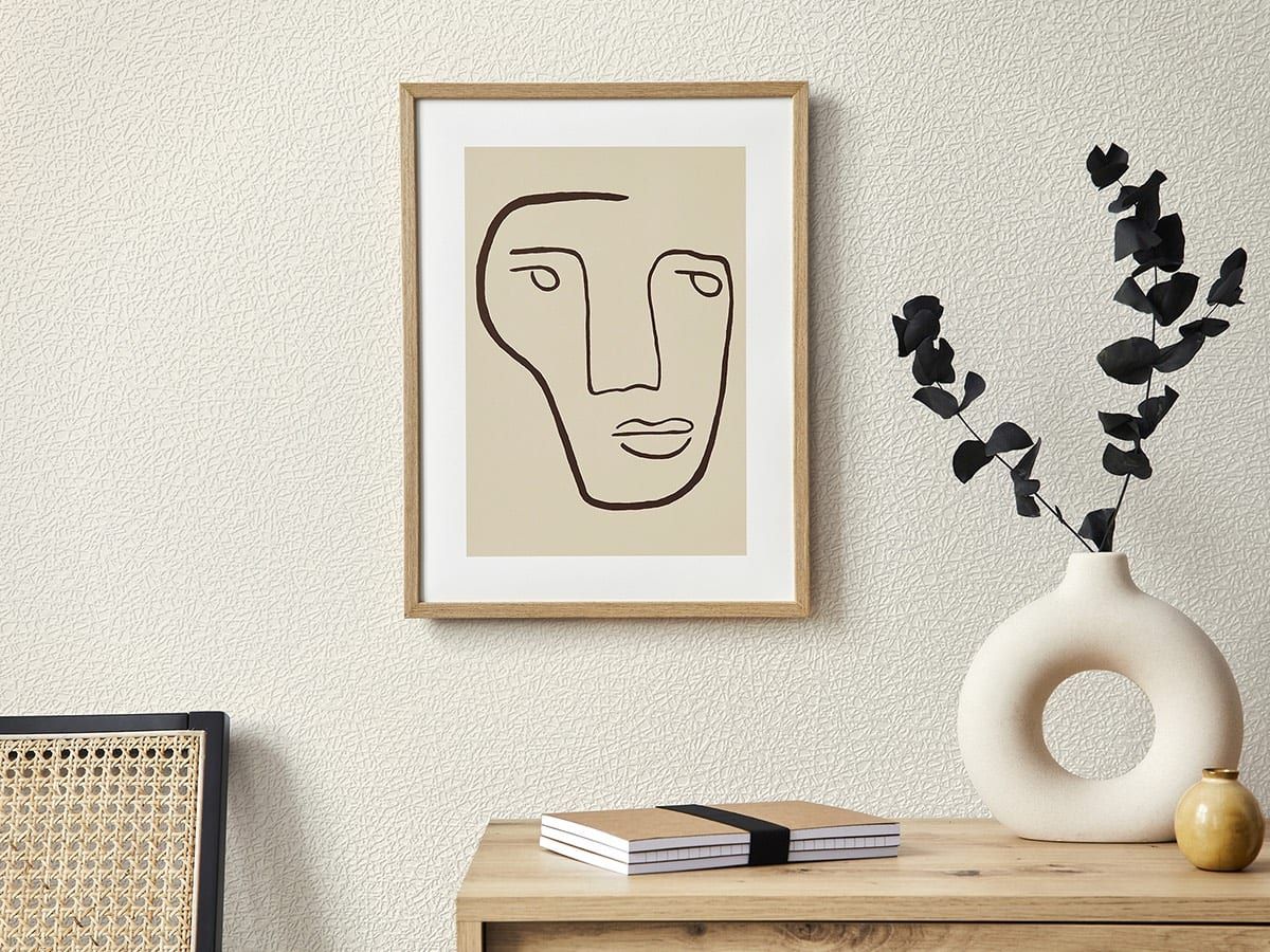 Strukturtapete in Leinenoptik — cremefarbene Wand in Nahsicht hinter Bild und Sideboard
