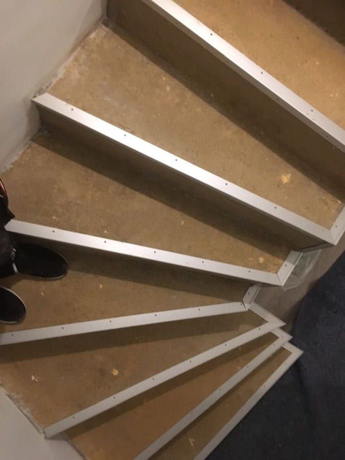 Betonstufen mit PVC-Designbelag verkleidet — vorher: rohe Betonstufen mit montierten Kantenprofilen