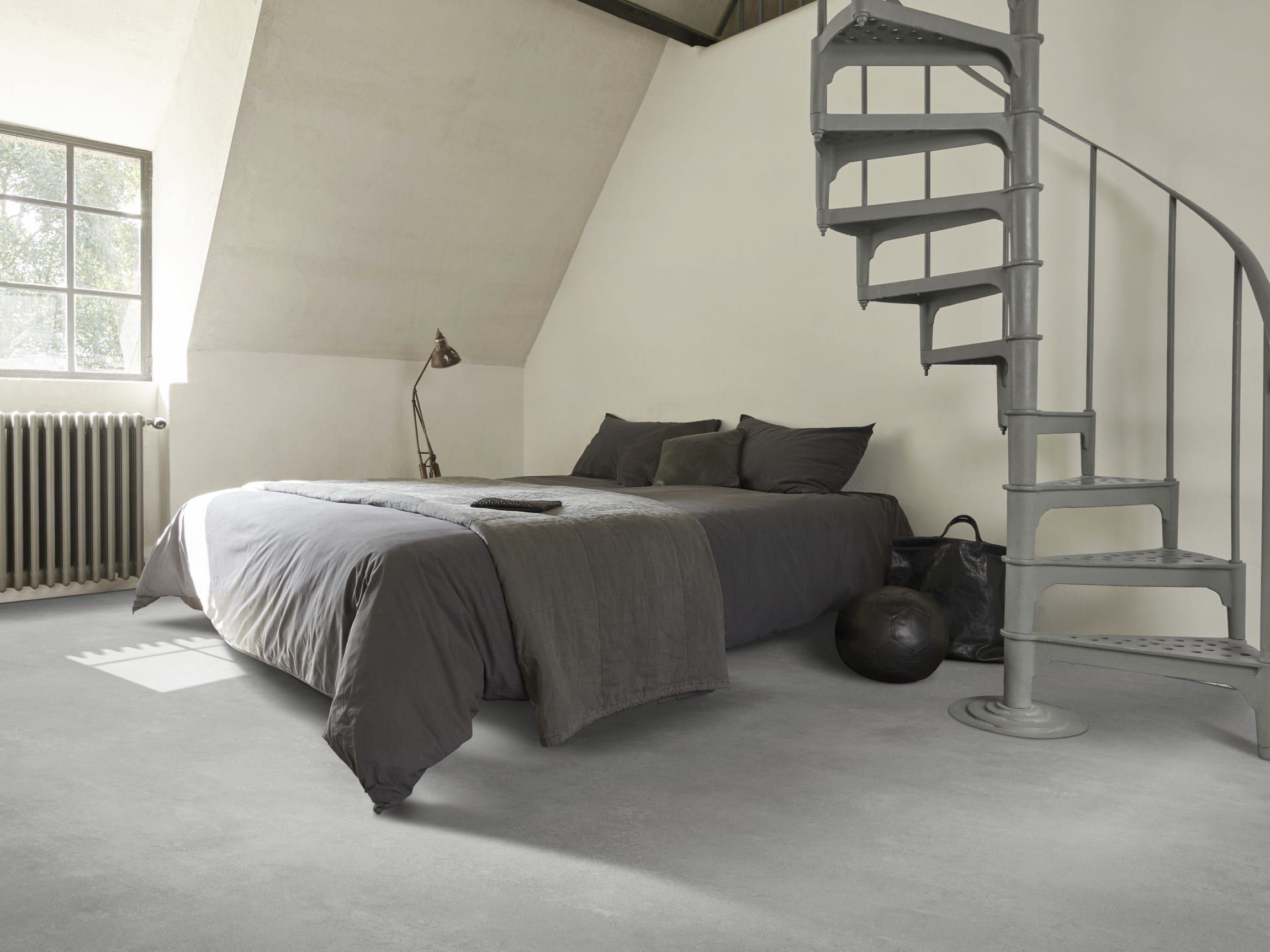 Elastischer Bodenbelag im Wohnbereich — grauer Boden im Schlafzimmer neben der Wendeltreppe